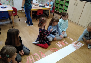 dziewczynki układają napis "DZIEŃ CHŁOPAKA"